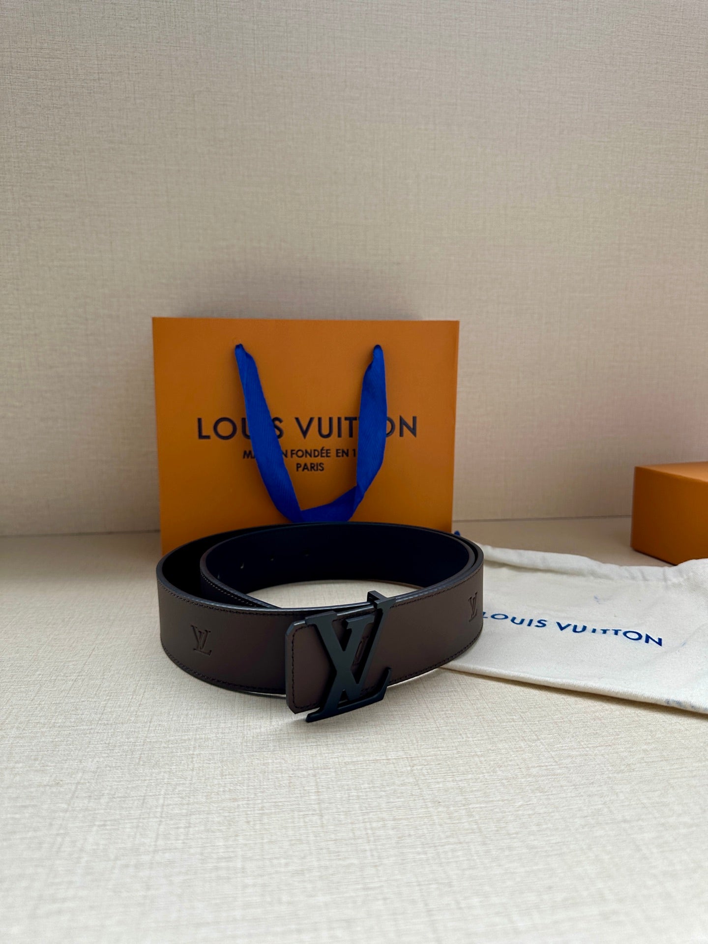 Louis Vuitton belt on display: dark brown strap with LV buckle front