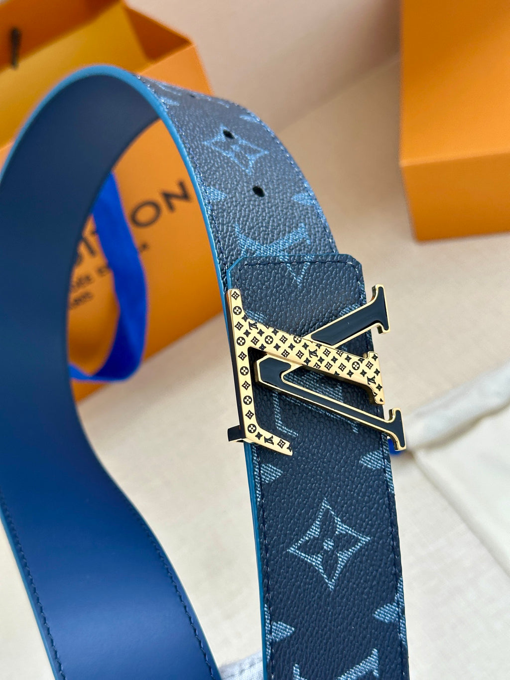 Louis Vuitton belt close-up with navy monogram pattern and metal buckle