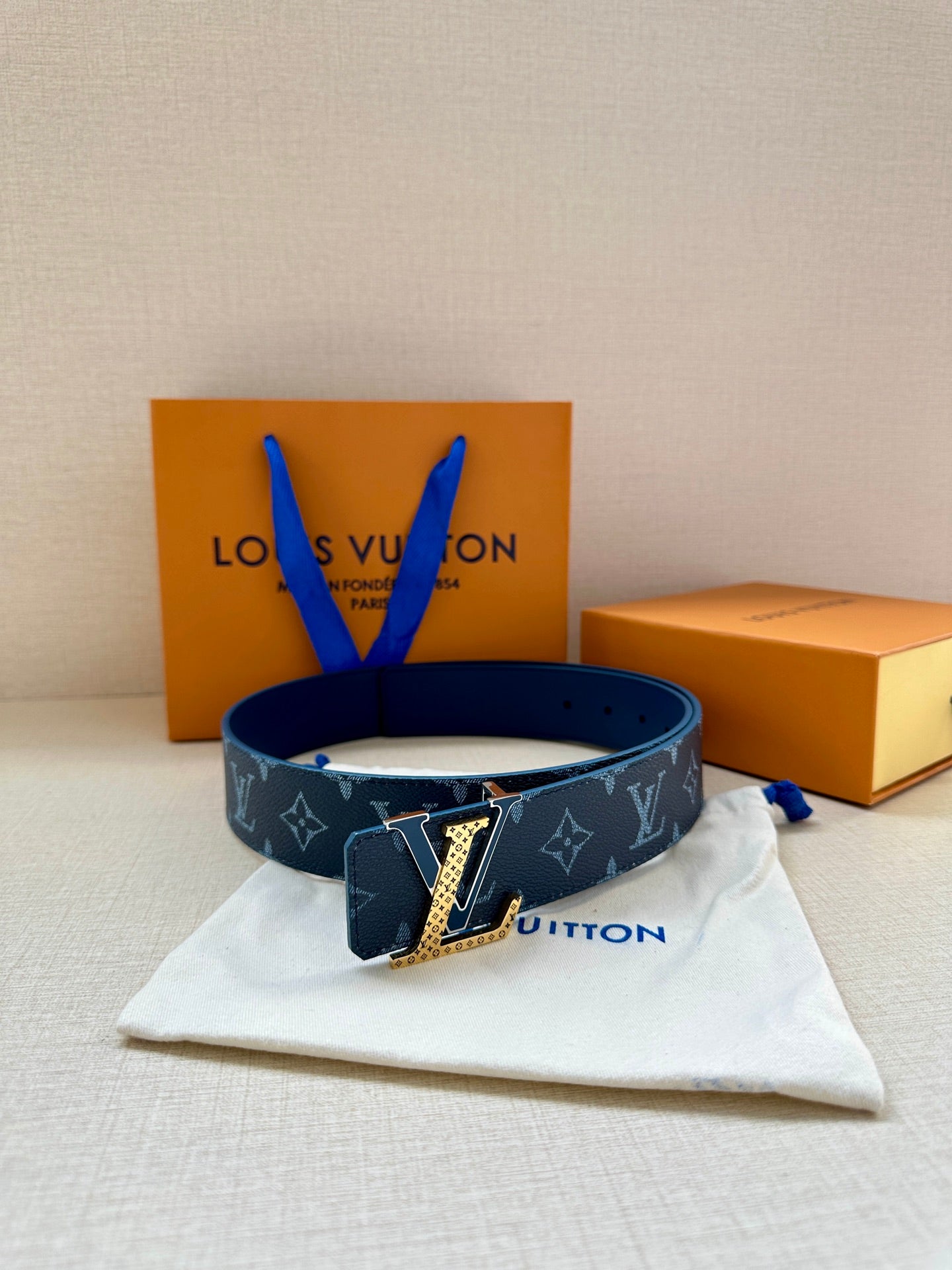 Louis Vuitton belt on dust bag, navy monogram strap with gold buckle