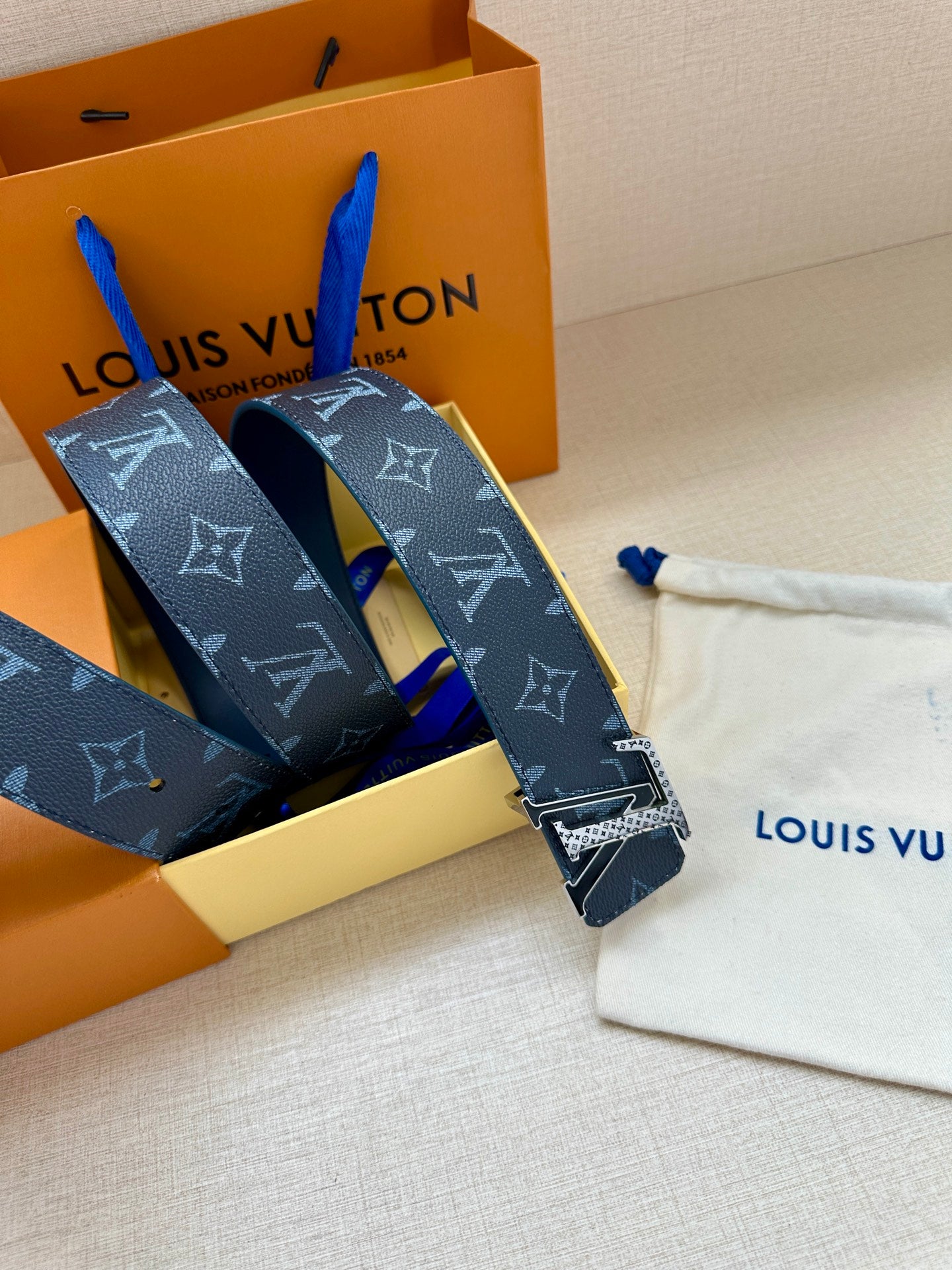 Louis Vuitton belt straps with navy monogram pattern and gold buckle