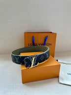 Monogram belt with dark canvas strap and gold-tone buckle on olive leather lining