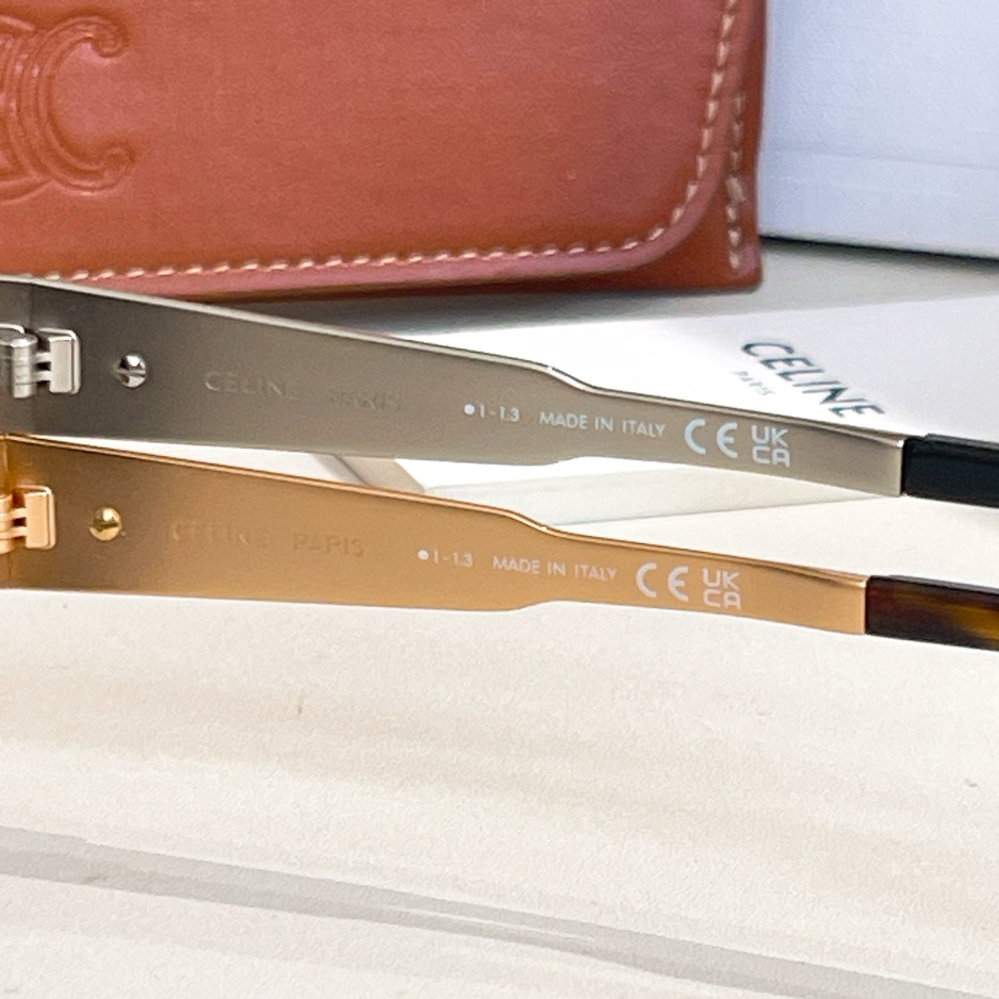 Gold-tone sunglasses showing inside arm with printed text and CE marking