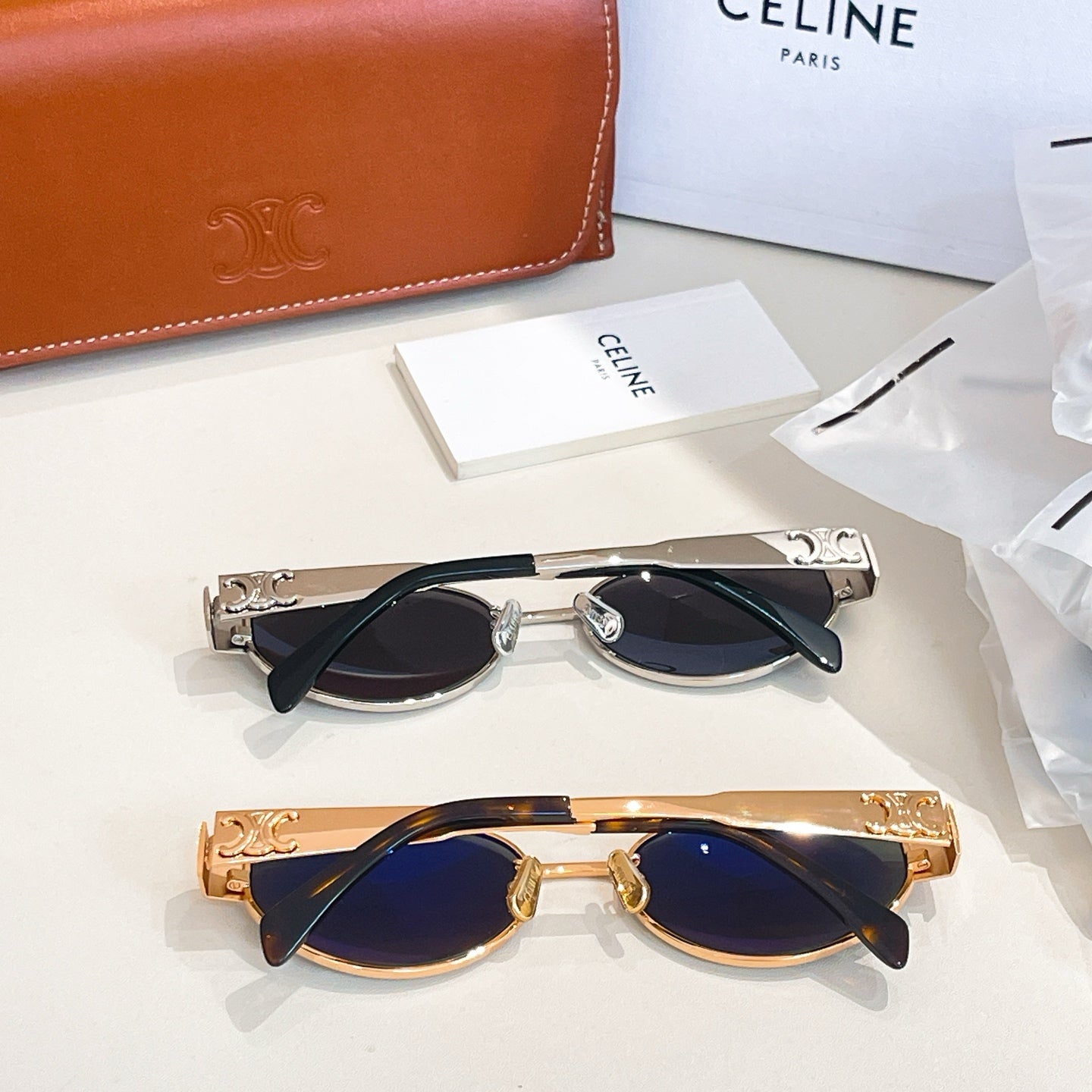 Sunglasses pair with silver-tone and gold-tone frames and dark lenses