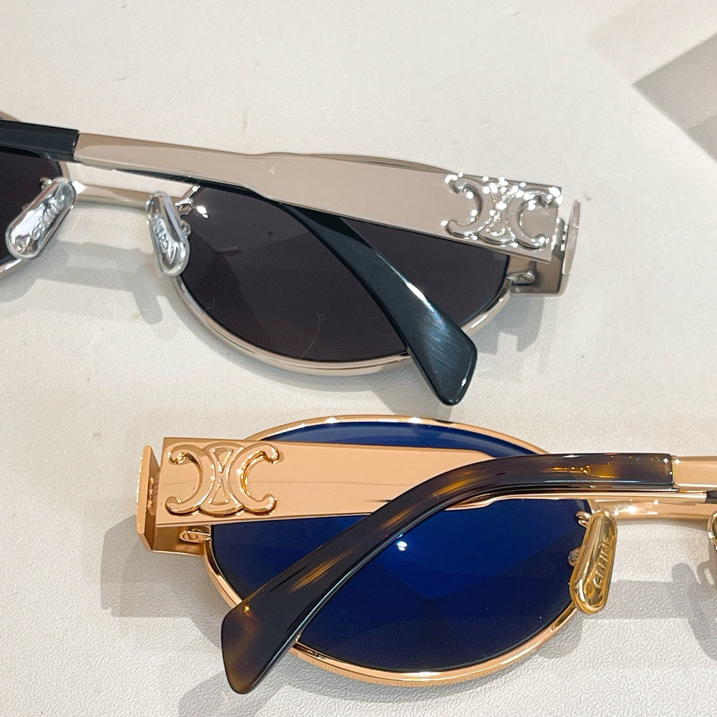 Gold-tone cat-eye sunglasses with dark lenses and patterned temple accents