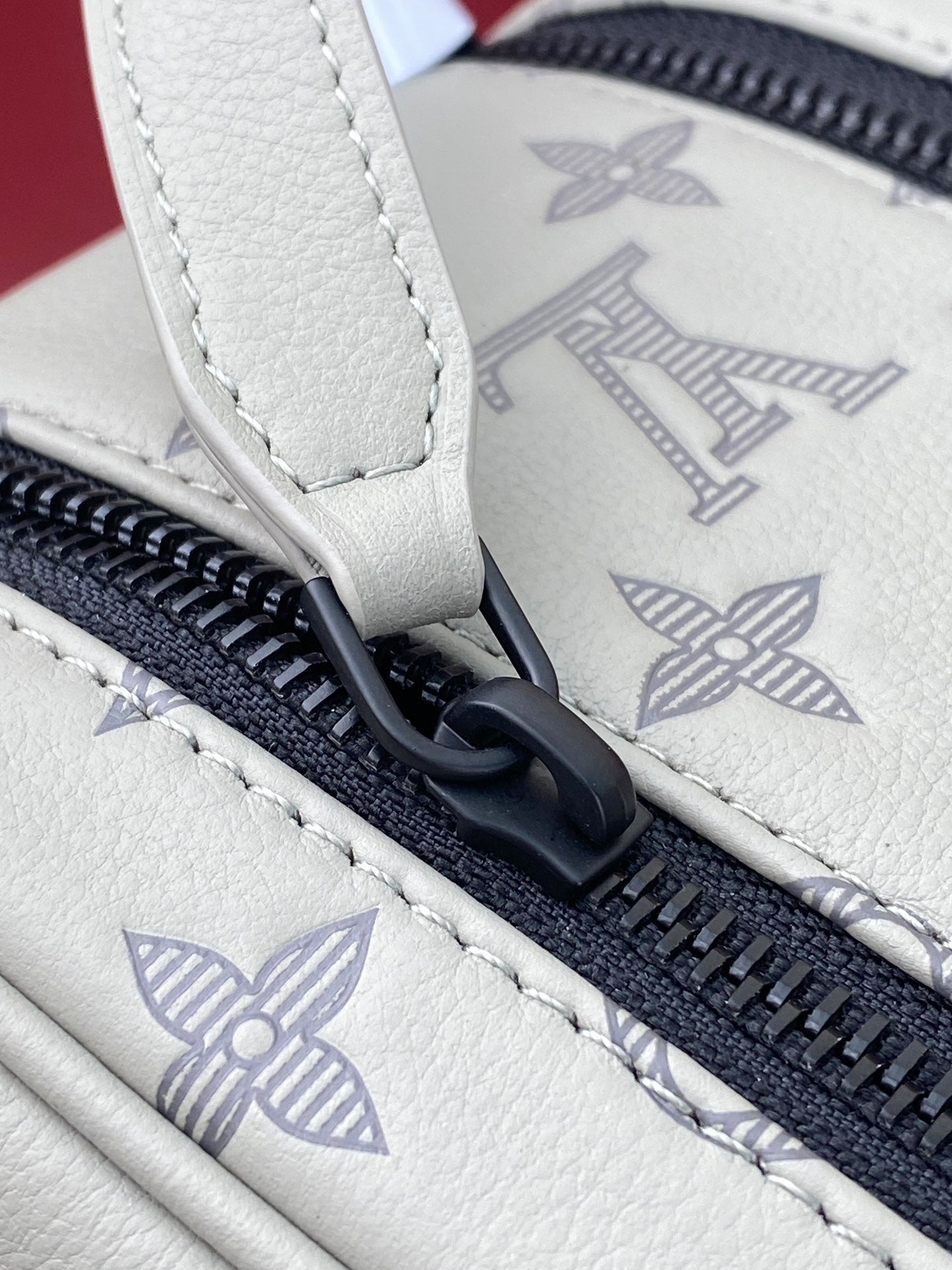 Louis Vuitton monogram toiletry bag zipper pull with navy zipper and stitched seam