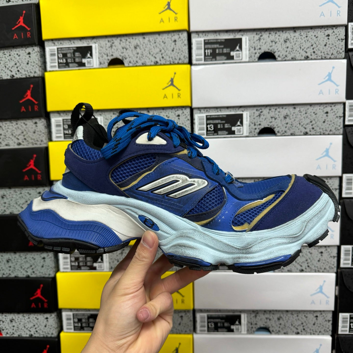 Balenciaga lace-up sneakers, blue upper and white midsole held in hand