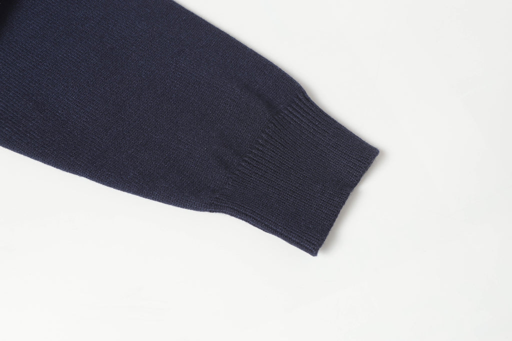 Dark navy knit sweater sleeve cuff with ribbed trim.