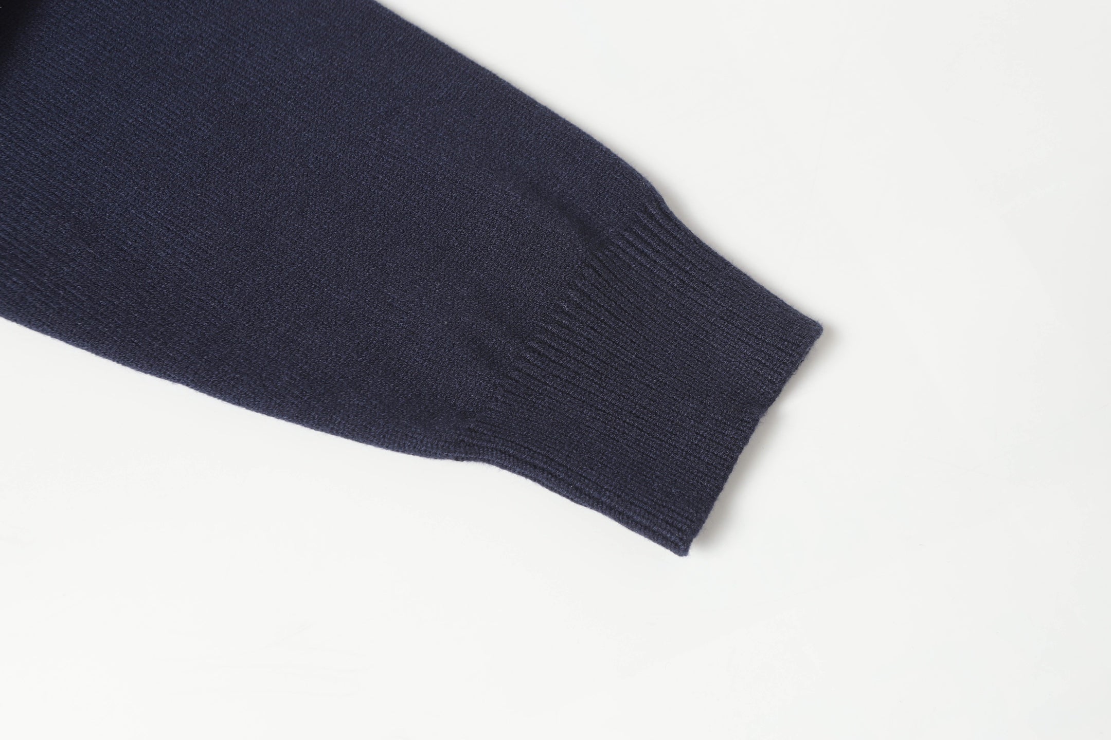 Dark navy knit sweater sleeve cuff with ribbed trim.