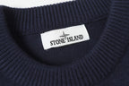 Stone Island logo label at the neck of a dark navy knit sweater.