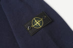 Stone Island logo patch on dark navy sleeve, embroidered in green and gold.