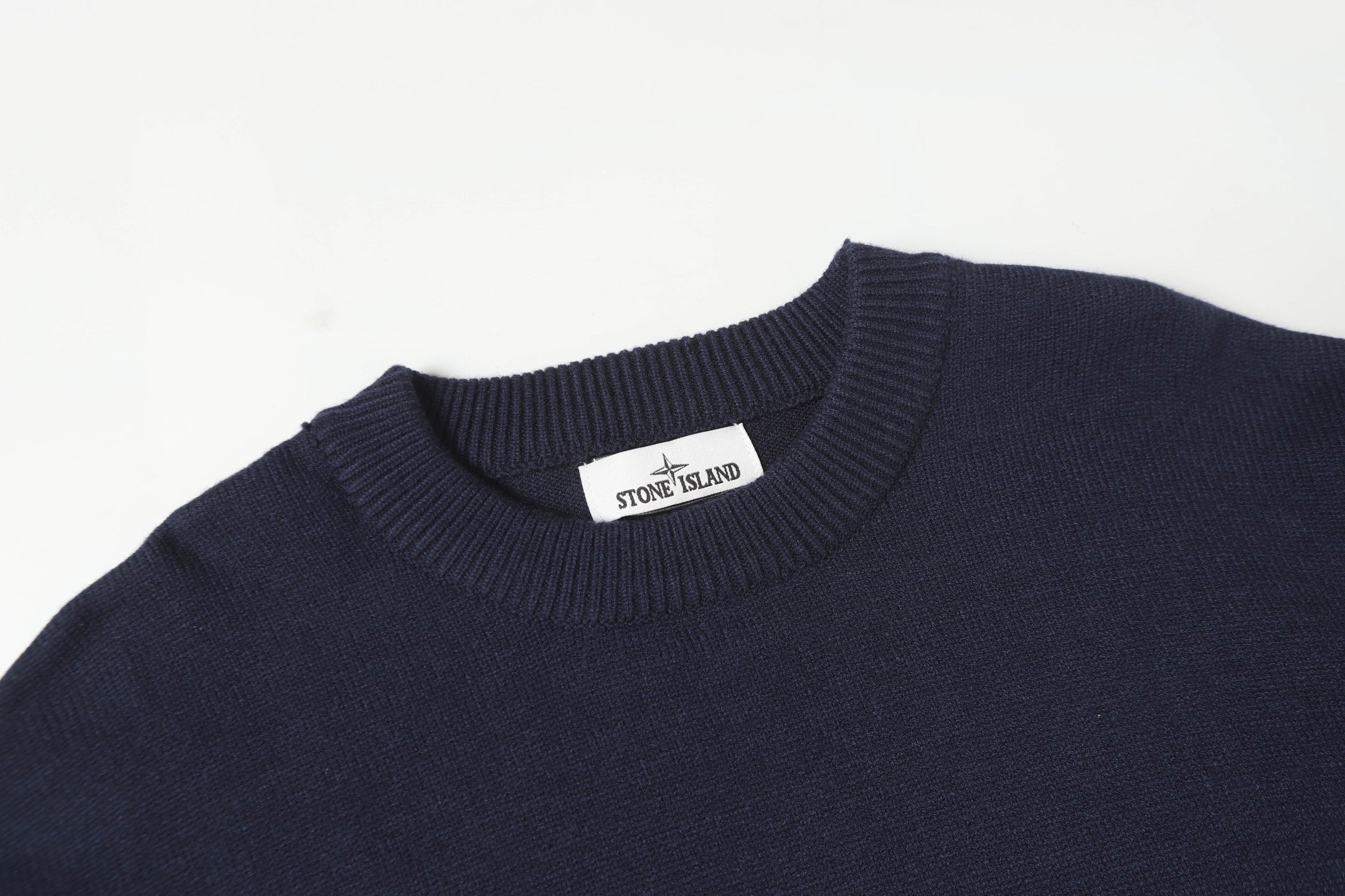 Crewneck knit sweater neckline with Stone Island logo patch on the collar.