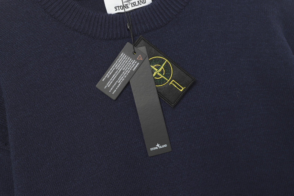 Crewneck knit sweater collar with hanging brand tags and Stone Island patch detail.