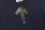 Crewneck knit sweater collar with hanging brand tags and Stone Island patch detail.