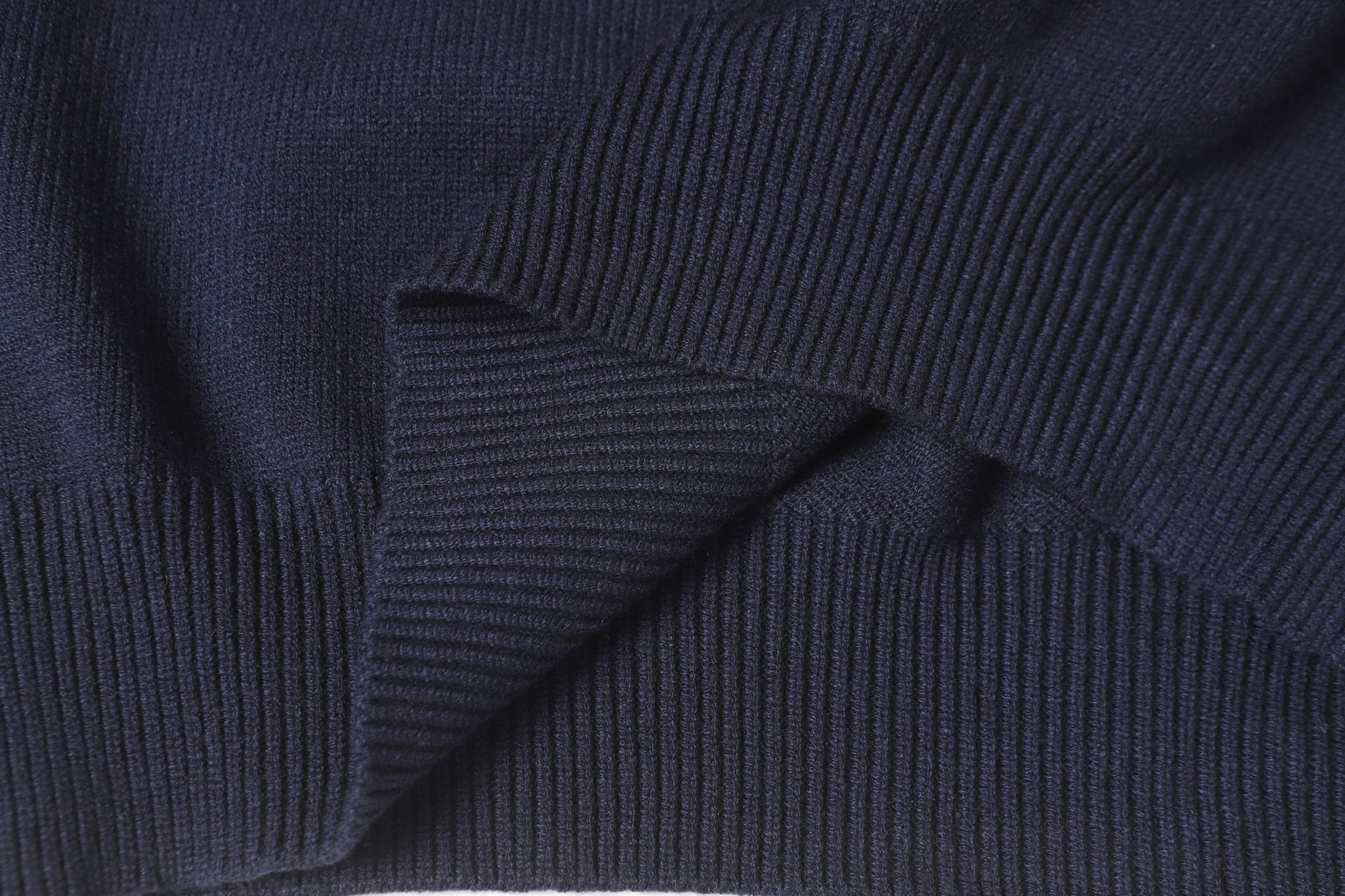 Dark navy knit sweater knit texture with ribbed shoulder and sleeve seam.