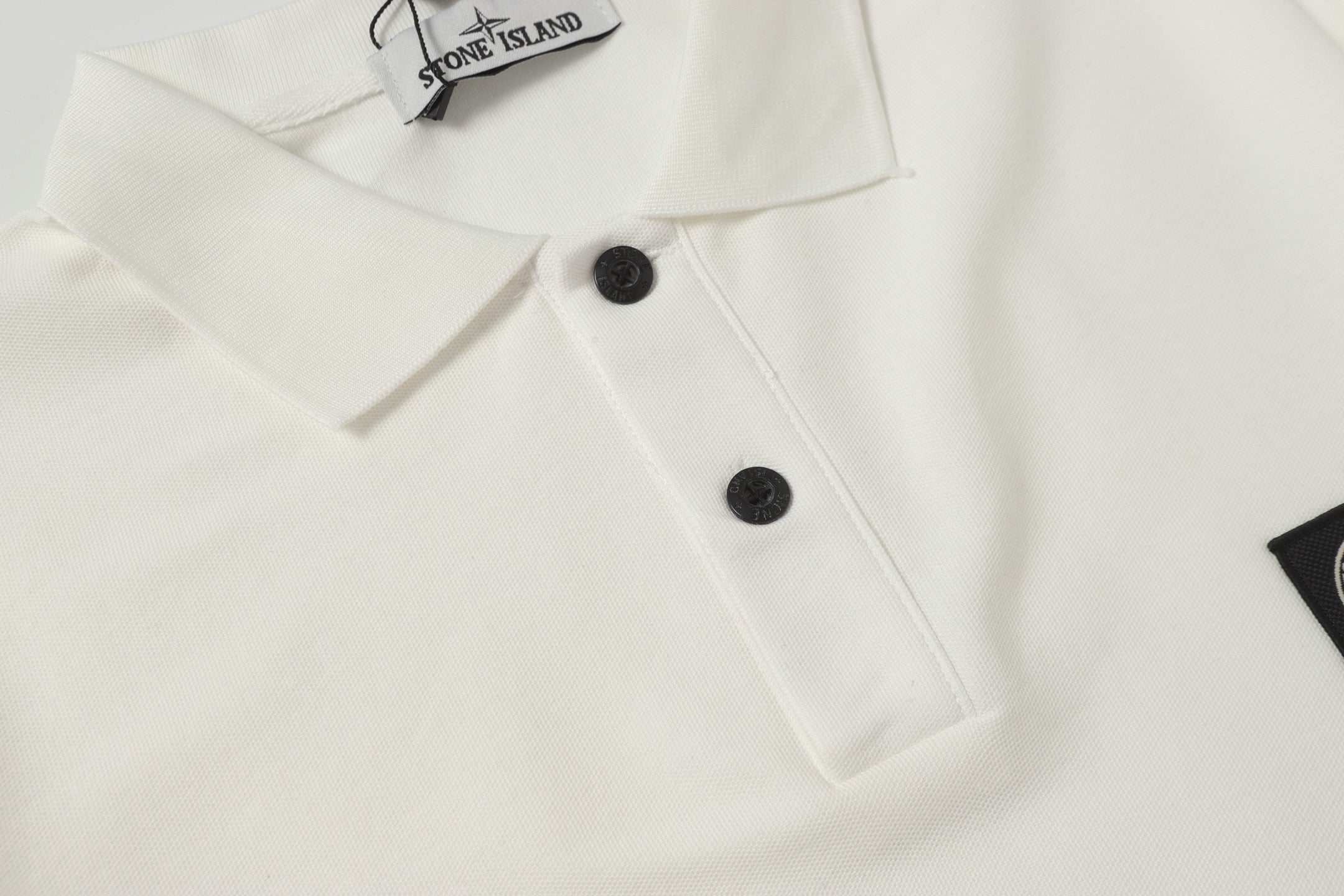 White polo shirt front with two black buttons and raised collar