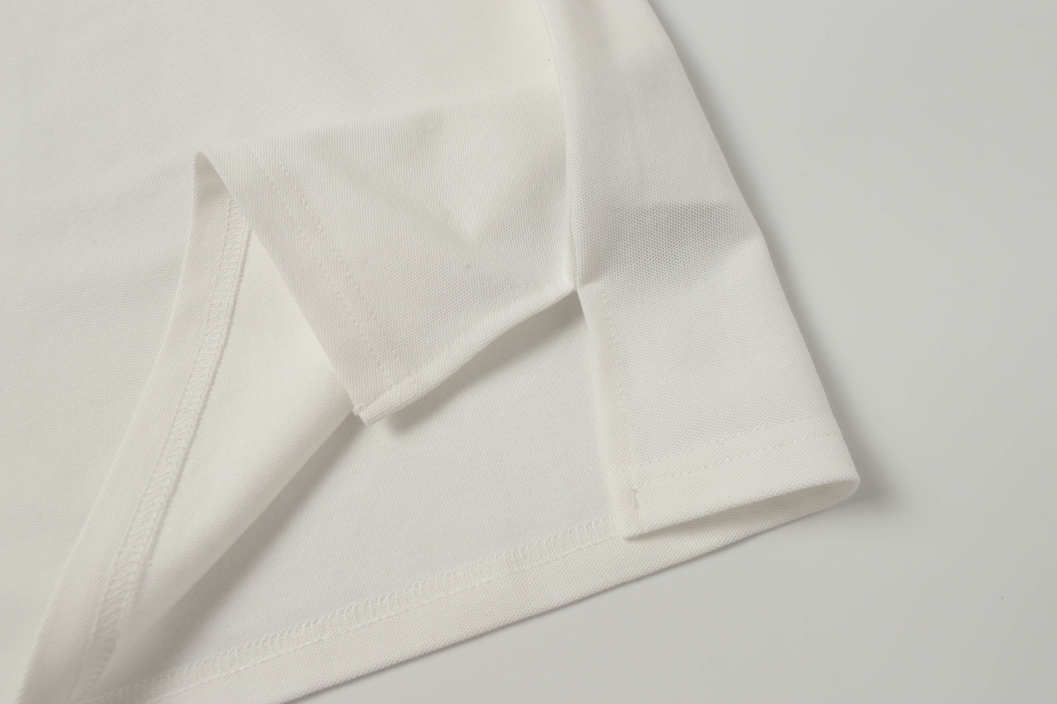 White polo shirt cuff and sleeve seam close-up