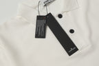 White polo shirt collar with black button and hanging size tag
