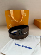 Monogram canvas belt with dark strap and black LV buckle, belt laid flat