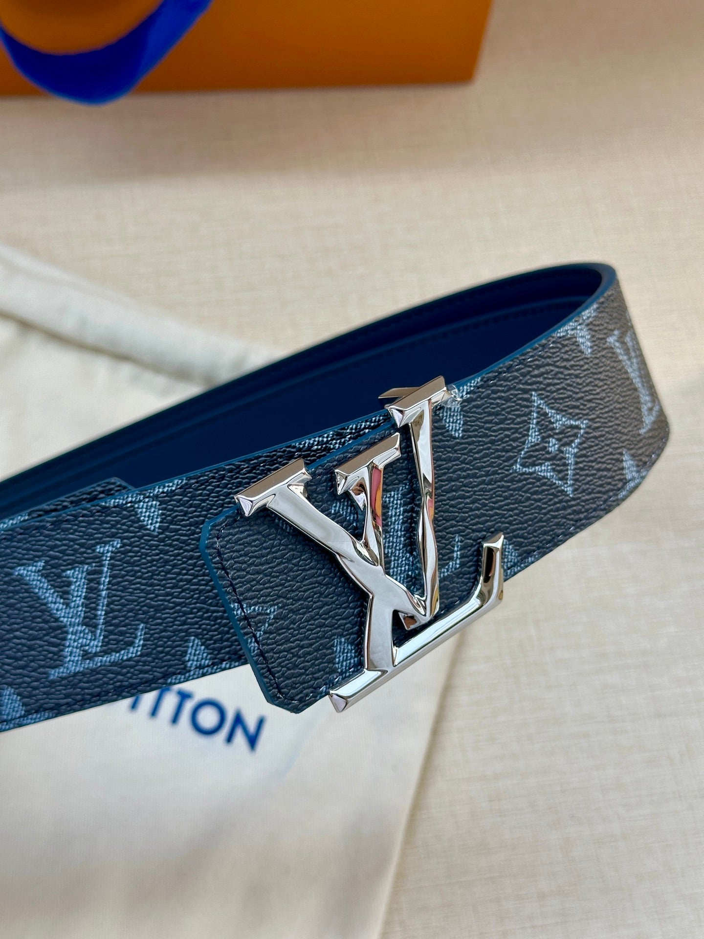 Louis Vuitton belt close-up: dark blue monogram strap with silver-toned LV buckle