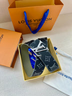 Louis Vuitton monogram belt laid flat with silver-tone buckle on dust bag
