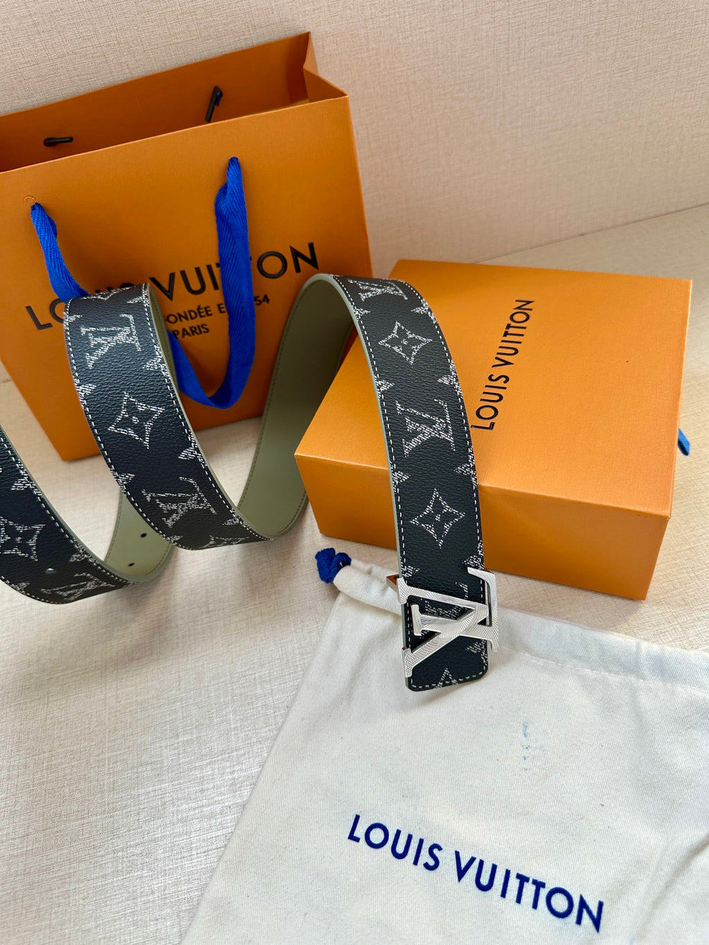 Louis Vuitton monogram belt with silver buckle, showing holes and keeper strap
