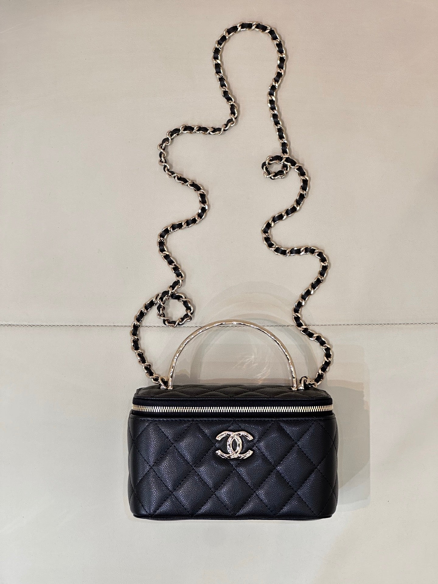 Dark navy quilted mini bag with top handle, chain strap, and front CC logo patch.