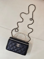 Dark navy quilted mini bag with crossbody chain strap and front CC logo emblem.