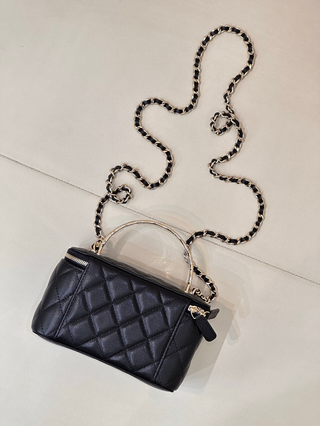 Dark navy quilted mini bag with top handle, front CC logo, and silver-tone chain strap.