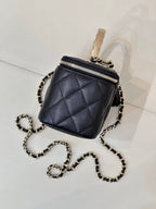 Dark navy quilted mini bag with top zip, chain crossbody strap, and gold-tone hardware.