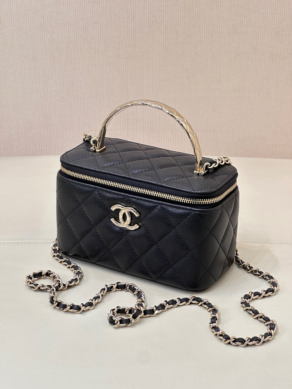 Dark navy quilted mini bag with top handle, front CC logo, and chain strap with loops.