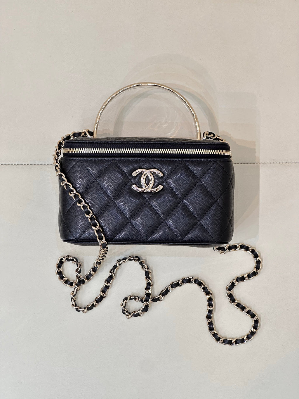 Dark navy quilted mini top-handle bag with double zip and gold-tone CC logo.