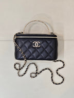 Dark navy quilted mini top-handle bag with double zip and gold-tone CC logo.