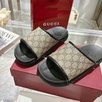 Gucci slide sandals on red box; tan GG canvas uppers with black pool-slide rubber sole