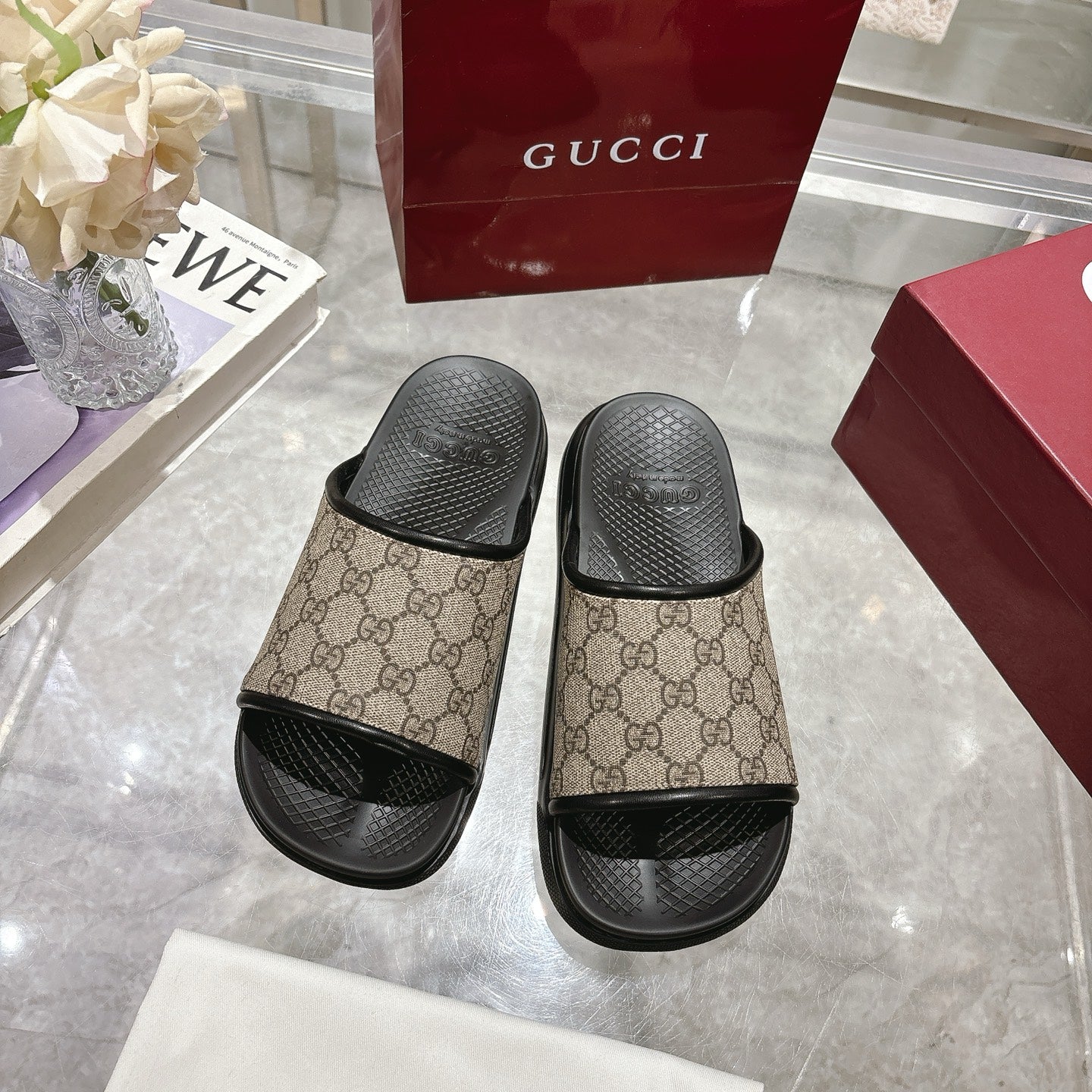 Gucci slide sandals pair; tan GG canvas uppers with black rubber straps and soles