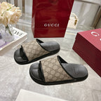 Gucci slide sandals with tan GG monogram straps and black footbed, curved black sole