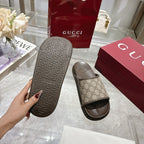 Gucci slide sandal outsole tread on one shoe; GG canvas strap on the other