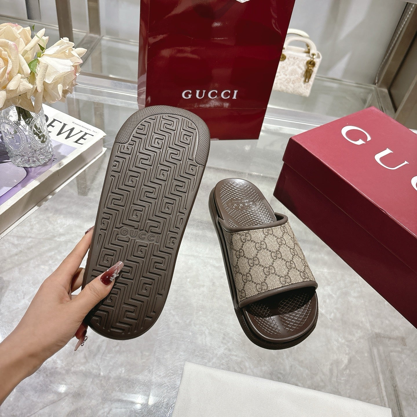 Gucci slide sandal outsole tread on one shoe; GG canvas strap on the other