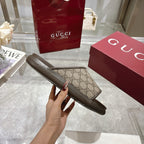 Gucci slide sandal shown from side, GG canvas strap with dark sole
