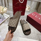 Gucci slide sandals with GG canvas uppers and dark slip-on rubber footbeds