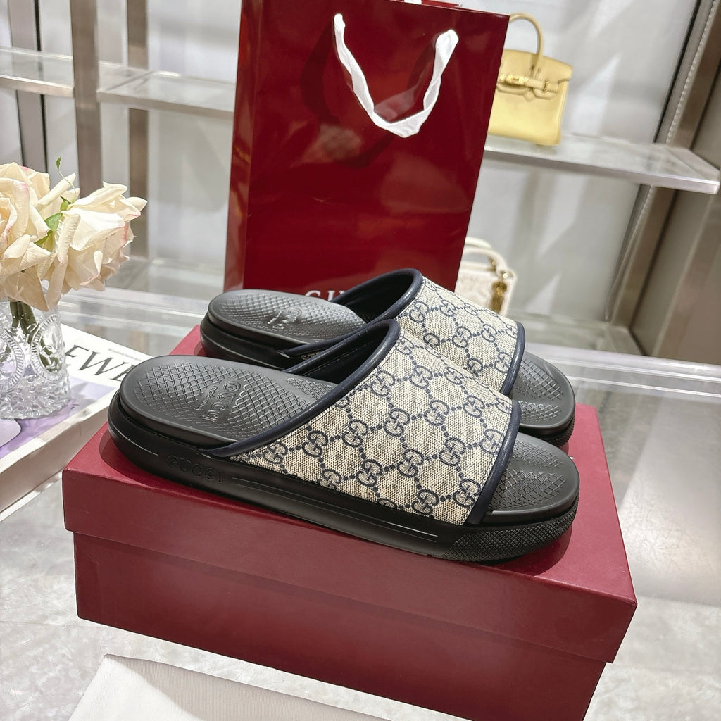 Pair of Gucci GG slide sandals with black footbed and textured black rubber sole