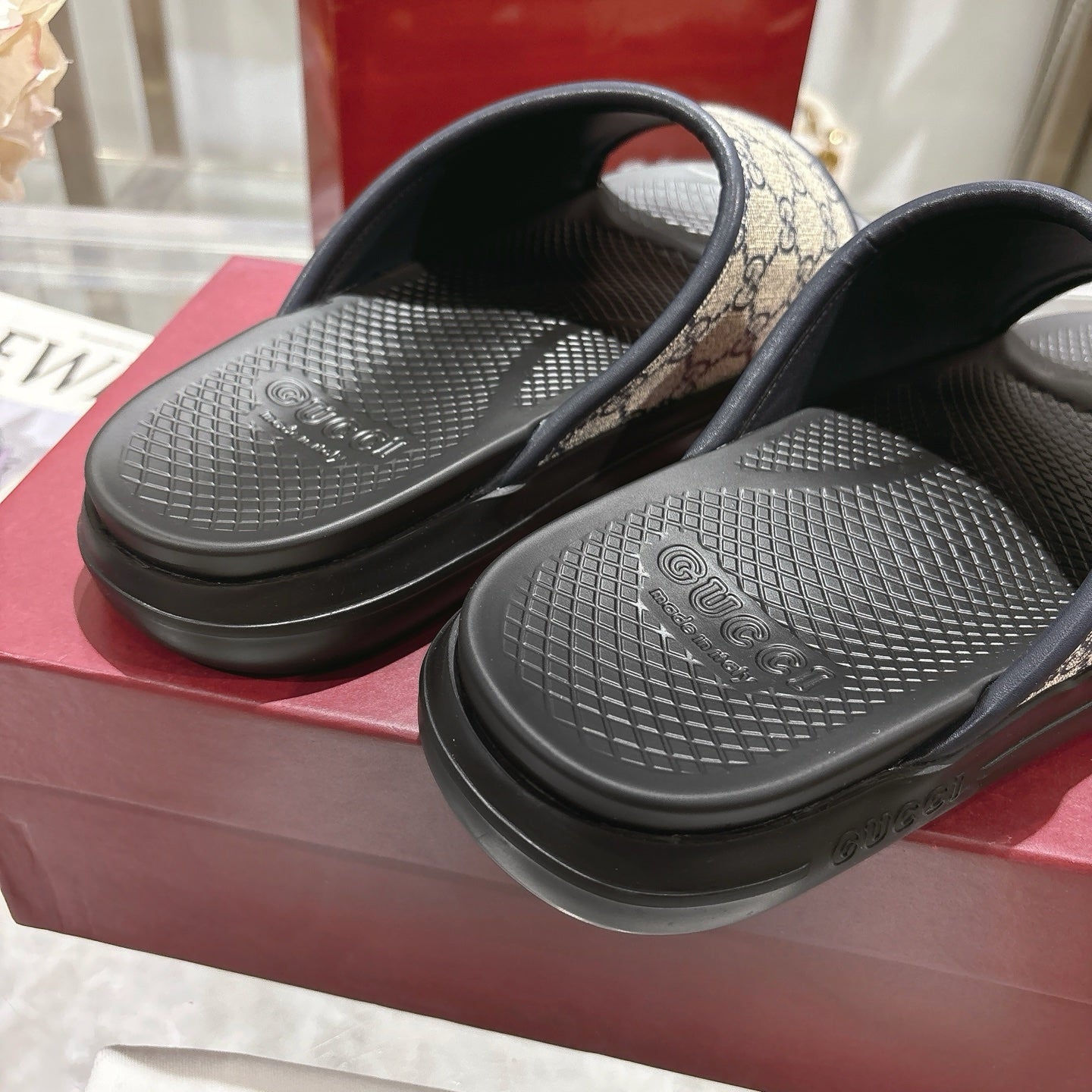 Close-up of Gucci GG slide sandals footbeds with textured black tread