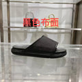 Gucci slide sandals in dark black with textured logo strap and cushioned footbed