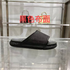 Gucci slide sandals in dark black with textured logo strap and cushioned footbed