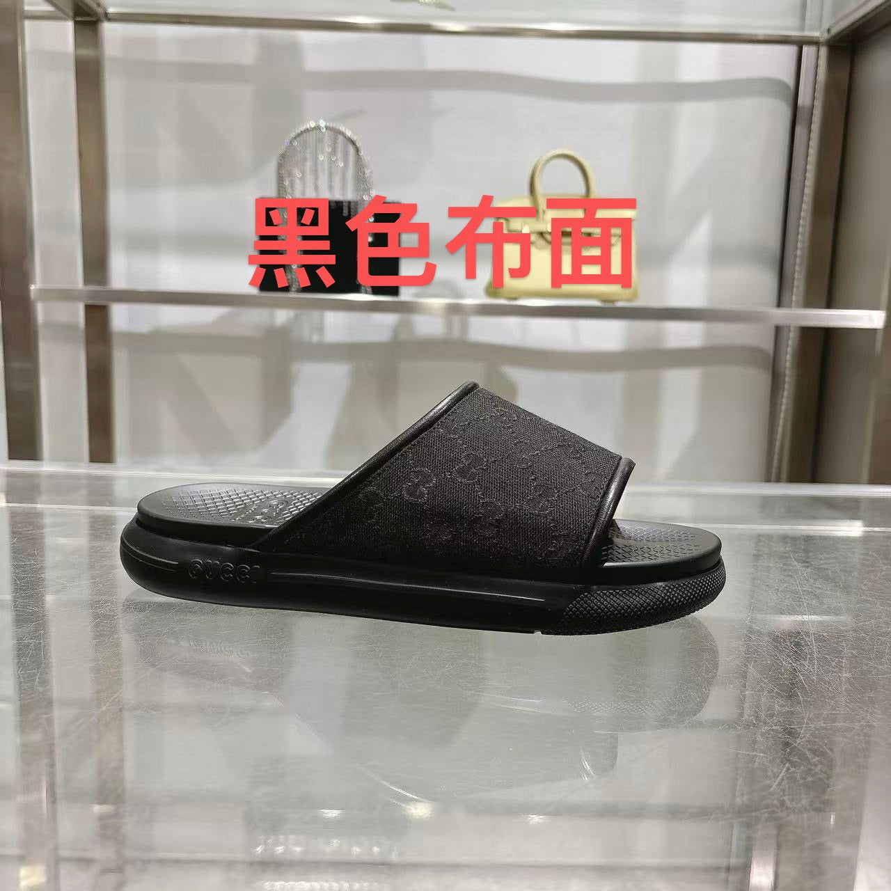 Gucci slide sandals in dark black with textured logo strap and cushioned footbed
