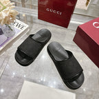 Gucci black monogram slide sandals with wide strap and molded footbed