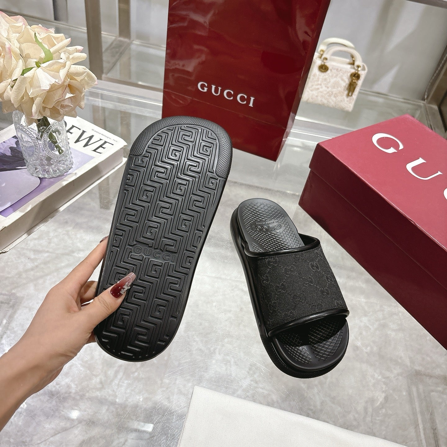 Gucci black slide sandals showing tread outsole on one footbed