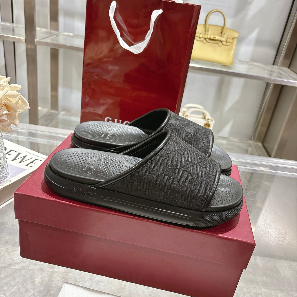 Gucci black slide sandals with monogram-pattern strap and textured rubber footbed