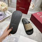 Gucci slide sandals outsole view: dark textured sole with beige GG canvas upper