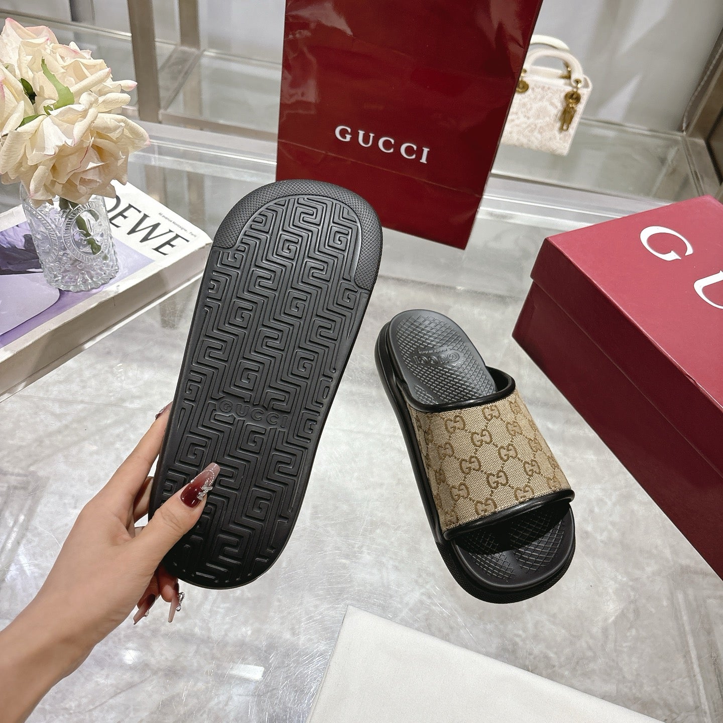 Gucci slide sandals outsole view: dark textured sole with beige GG canvas upper