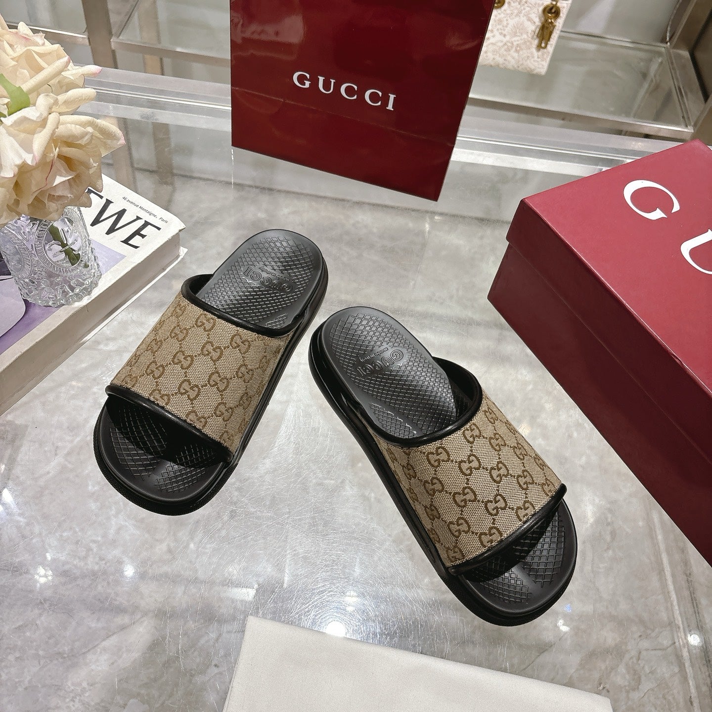 Gucci slide sandals, angled pair: beige GG canvas straps with black textured footbeds
